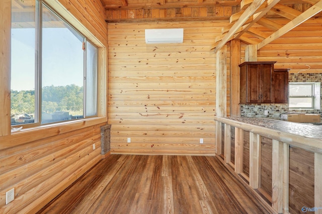 unfurnished dining area with beamed ceiling, hardwood / wood-style floors, and wooden walls