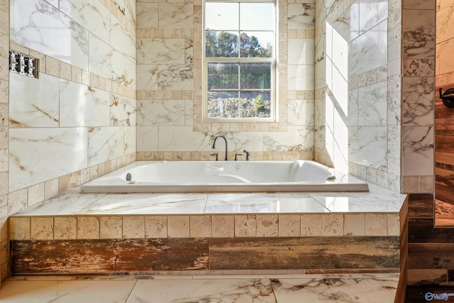 bathroom featuring a relaxing tiled tub and tile walls