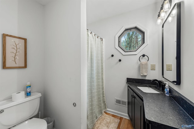 bathroom with hardwood / wood-style floors, toilet, curtained shower, and vanity