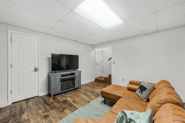 living room with dark wood-type flooring and a paneled ceiling