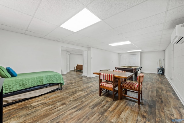 interior space featuring an AC wall unit, a paneled ceiling, and dark hardwood / wood-style flooring