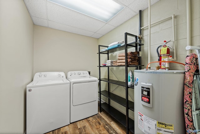 laundry area with washing machine and dryer, dark wood-type flooring, and water heater