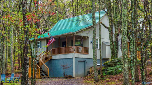 view of front of home featuring a porch, a garage, and central AC unit