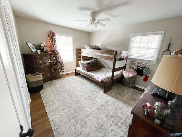 bedroom featuring ceiling fan, wood-type flooring, and multiple windows