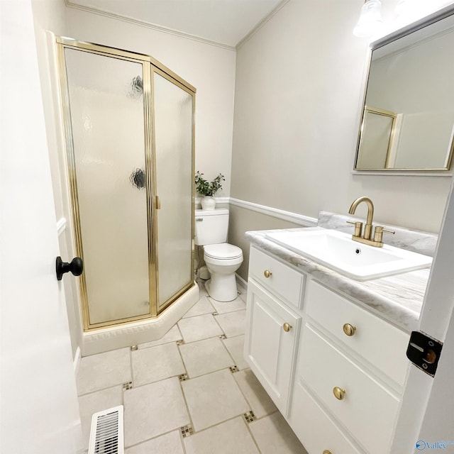 bathroom with tile patterned flooring, vanity, a shower with shower door, and toilet