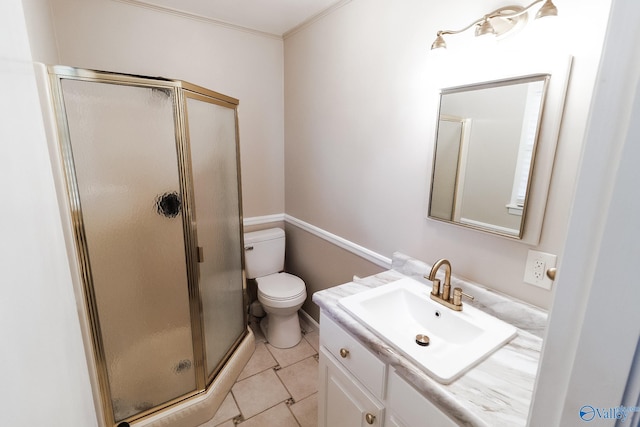 bathroom featuring tile patterned flooring, vanity, toilet, a shower with door, and crown molding