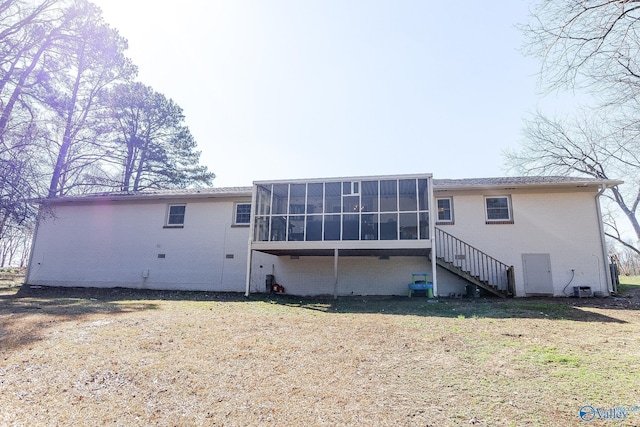 back of property featuring a lawn and a sunroom