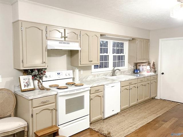 kitchen featuring white appliances, a textured ceiling, sink, wood-type flooring, and cream cabinets