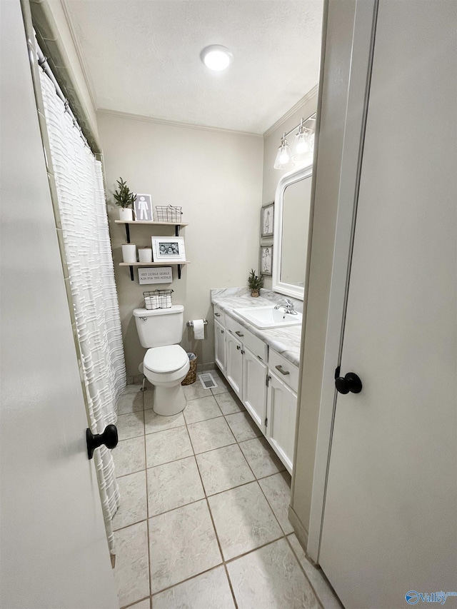 bathroom with tile patterned floors, crown molding, vanity, and toilet