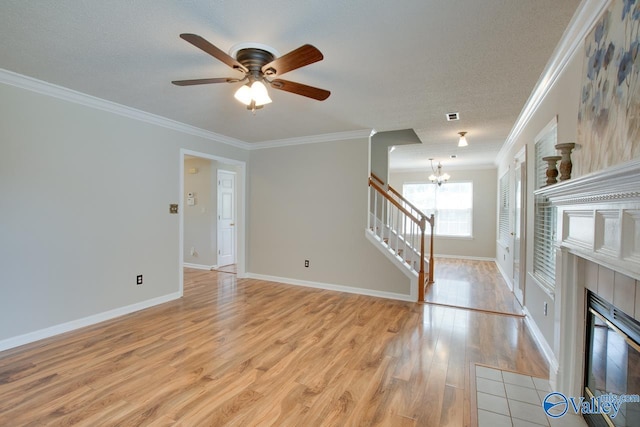 unfurnished living room featuring ornamental molding, light wood-type flooring, a chandelier, stairway, and a ceiling fan