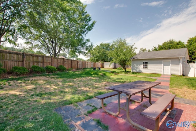 view of yard with an outdoor structure, a patio, outdoor dining space, and a storage shed