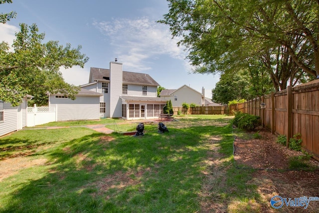 back of property featuring a chimney and a sunroom