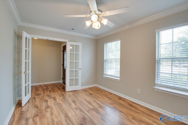 unfurnished room with french doors, light wood-type flooring, ornamental molding, a ceiling fan, and baseboards