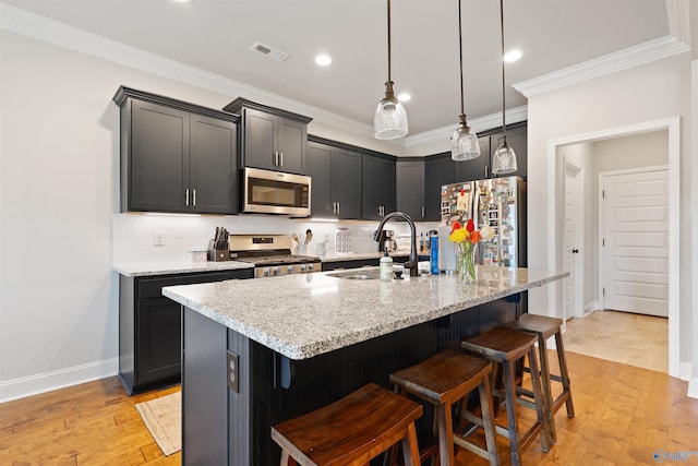 kitchen with crown molding, stainless steel appliances, visible vents, and a sink