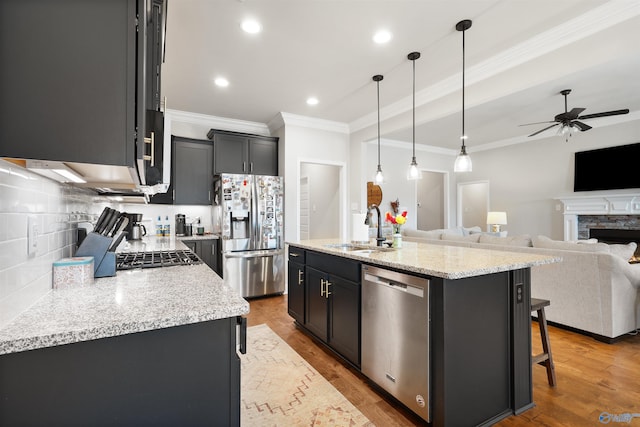 kitchen featuring a sink, crown molding, open floor plan, a ceiling fan, and appliances with stainless steel finishes