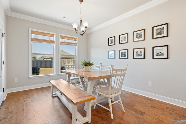 dining space featuring baseboards, crown molding, a chandelier, and visible vents