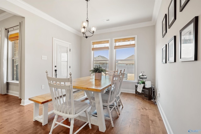 dining area featuring crown molding and light wood-type flooring