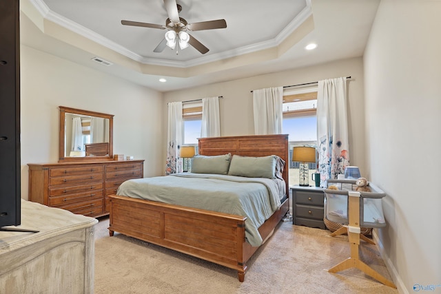 bedroom with multiple windows, ornamental molding, a raised ceiling, and light colored carpet