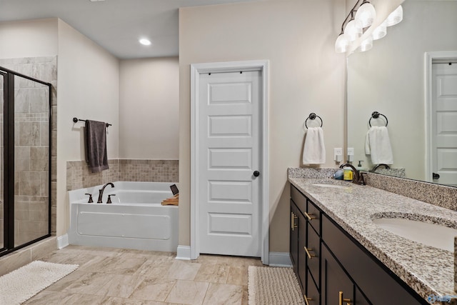 full bath featuring double vanity, a garden tub, a sink, baseboards, and a shower stall