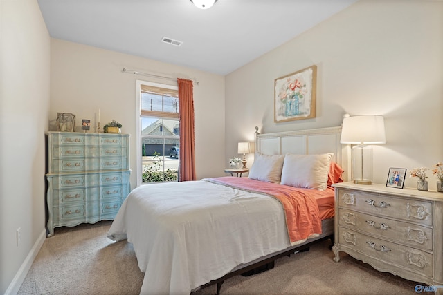 bedroom featuring visible vents, baseboards, and light carpet
