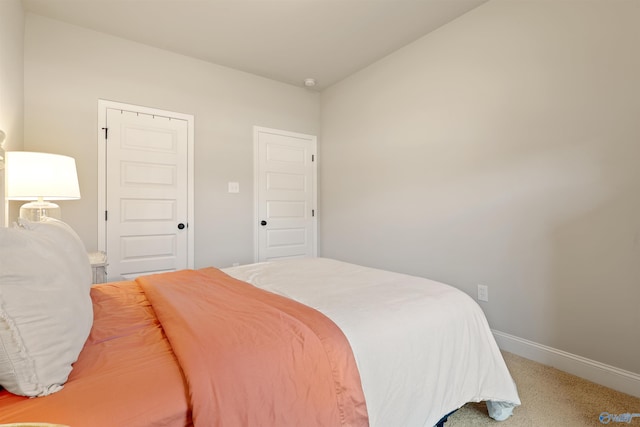 bedroom featuring light carpet and baseboards
