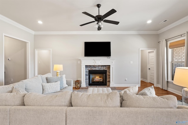 living area with a ceiling fan, baseboards, visible vents, and crown molding
