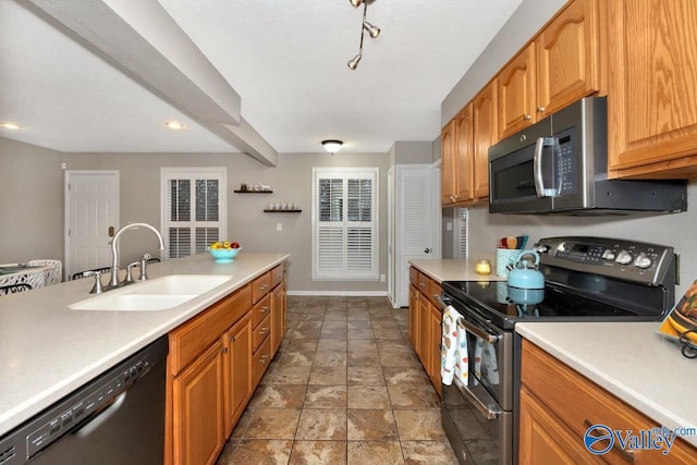 kitchen featuring stainless steel appliances, a sink, and light countertops