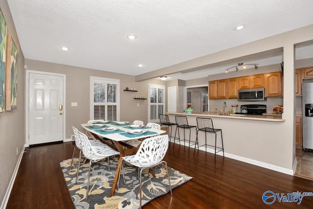 dining area featuring dark wood-style floors, recessed lighting, a textured ceiling, and baseboards