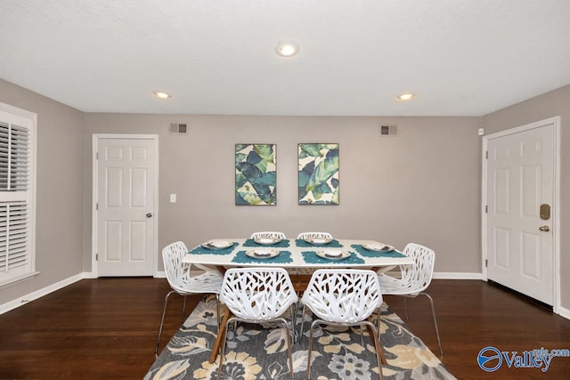 dining area with baseboards, visible vents, and wood finished floors