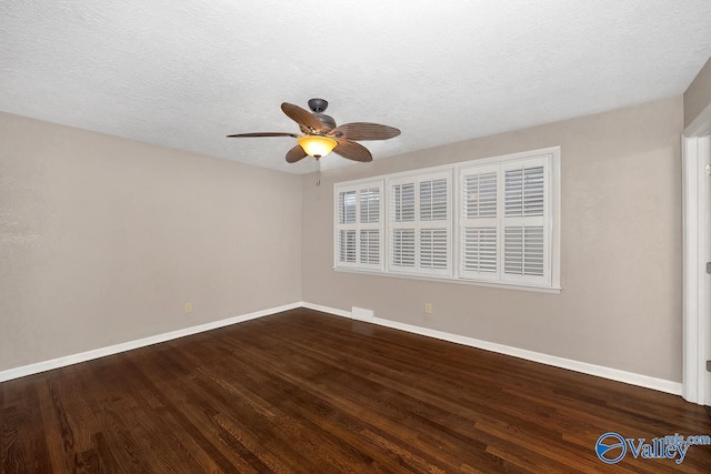 empty room with a textured ceiling, ceiling fan, wood finished floors, and baseboards