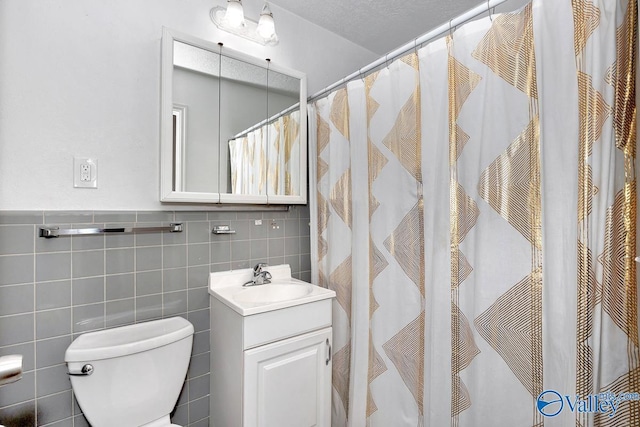 bathroom with curtained shower, vanity, toilet, and tile walls