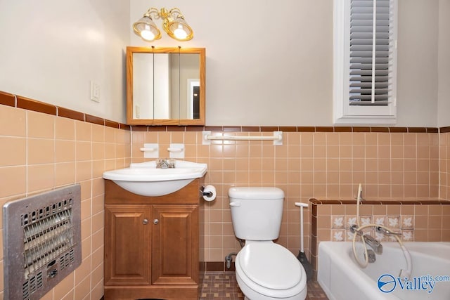 bathroom featuring toilet, tile walls, vanity, a bath, and heating unit