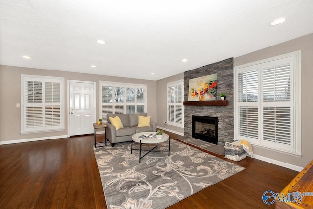 living area featuring a textured ceiling, recessed lighting, a fireplace, wood finished floors, and baseboards