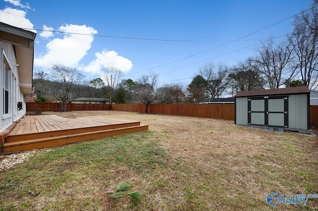 view of yard with a storage shed, an outdoor structure, a fenced backyard, and a wooden deck