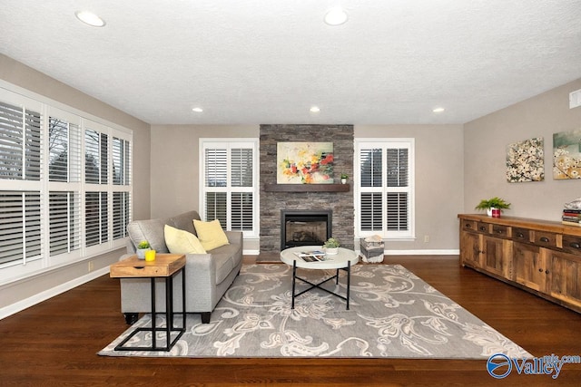 living room featuring a stone fireplace, recessed lighting, wood finished floors, and baseboards