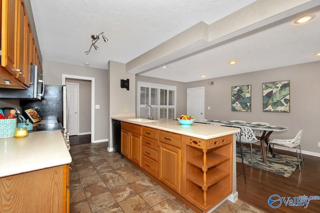 kitchen featuring black dishwasher, baseboards, decorative backsplash, light countertops, and a sink