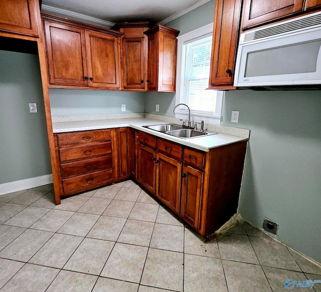 kitchen featuring light tile patterned floors, ornamental molding, and sink