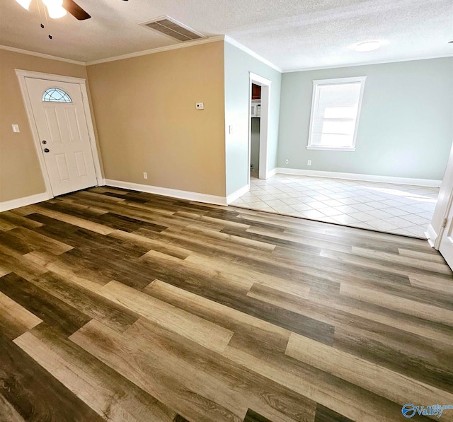 unfurnished room with crown molding, hardwood / wood-style flooring, a textured ceiling, and ceiling fan