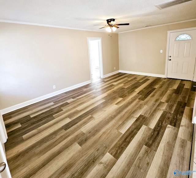 interior space featuring ceiling fan, a textured ceiling, wood-type flooring, and ornamental molding