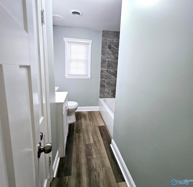 bathroom with vanity, toilet, and hardwood / wood-style flooring