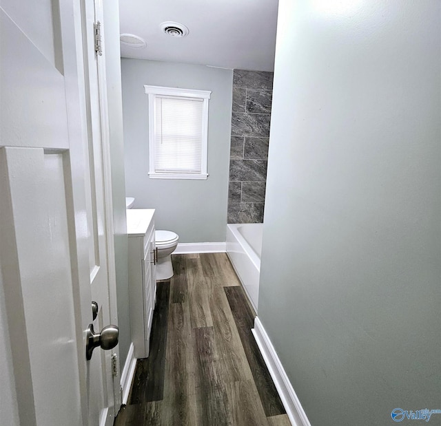 full bath featuring toilet, visible vents, wood finished floors, and vanity