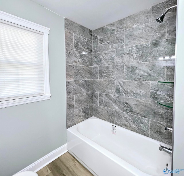 bathroom featuring tiled shower / bath combo and wood-type flooring