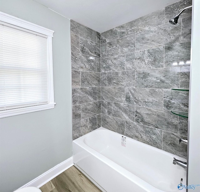 full bath with baseboards, shower / tub combination, and wood finished floors
