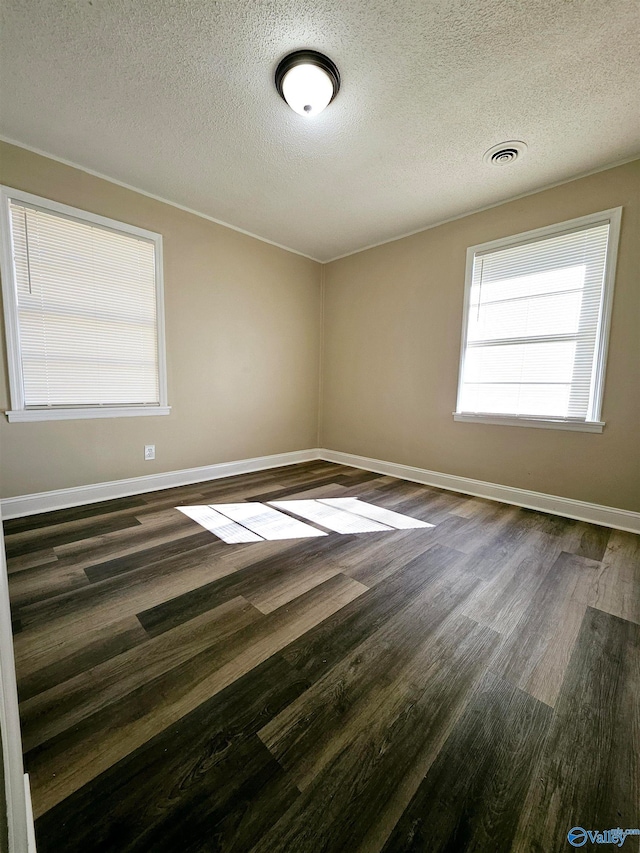 empty room featuring a textured ceiling and dark hardwood / wood-style flooring