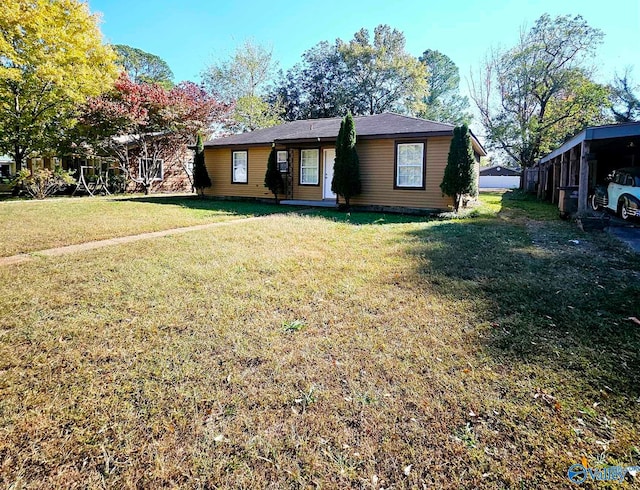 view of front of property with a carport and a front lawn