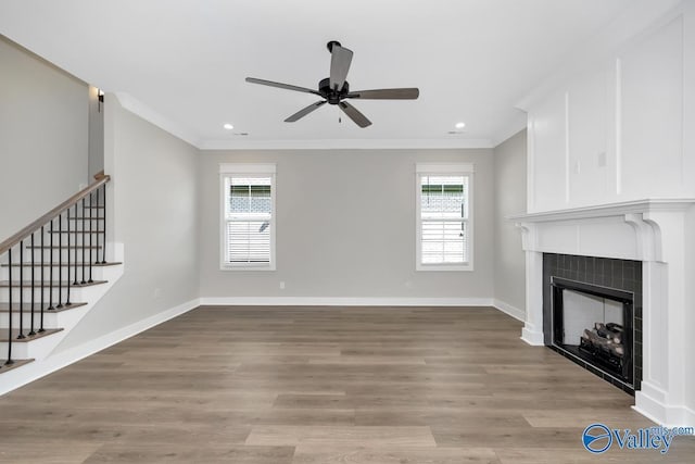 111 Mayapple Trl, Madison, AL 35756 - unfurnished living room featuring crown molding, baseboards, stairway, a tile fireplace, and a ceiling fan