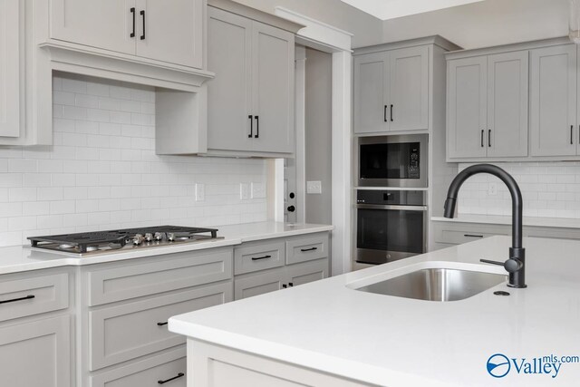 111 Mayapple Trl, Madison, AL 35756 - kitchen featuring a sink, light countertops, gray cabinets, stainless steel appliances, and decorative backsplash