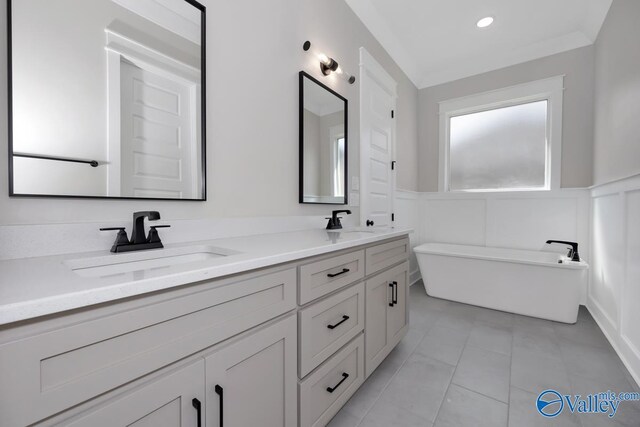 111 Mayapple Trl, Madison, AL 35756 - bathroom featuring double vanity, a sink, a freestanding bath, and a wainscoted wall