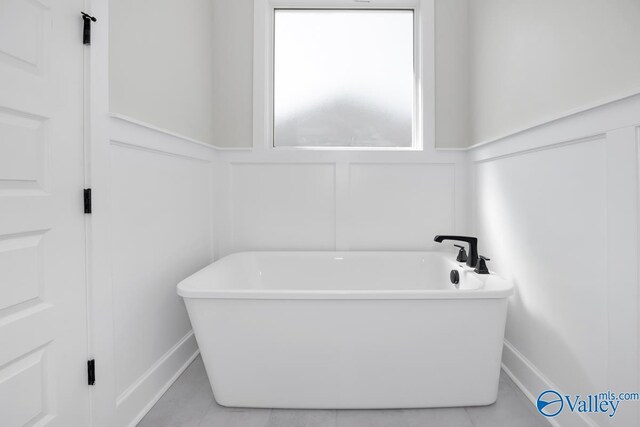 111 Mayapple Trl, Madison, AL 35756 - full bath with a wainscoted wall, tile patterned flooring, a decorative wall, and a soaking tub