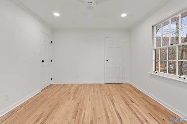 spare room featuring a healthy amount of sunlight, light hardwood / wood-style flooring, and crown molding